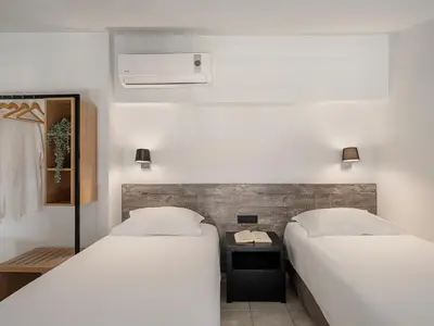 two beds in a small room with twoermottermott at Alexia Beach Hotel in Agia Marina Nea Kydonias