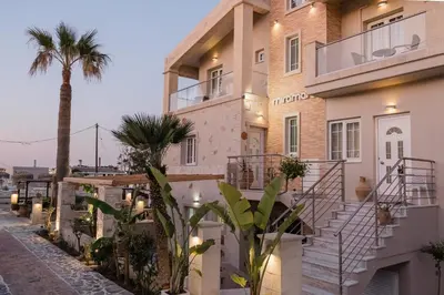 a building with a palm tree next to a street at Miramare Boutique Apartments in Plataniás