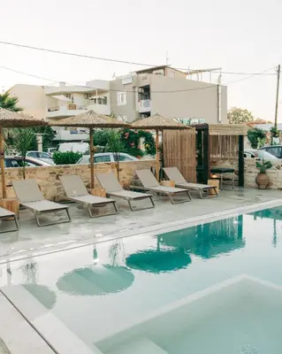 a pool at a hotel with chairs and umbrellas at Miramare Boutique Apartments in Plataniás