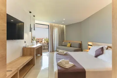 a bedroom with a large bed and a couch at Galini Palace in Kolymvari
