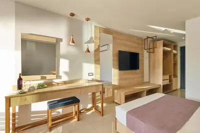 a bedroom with a bed and a desk and a television at Galini Palace in Kolymvari