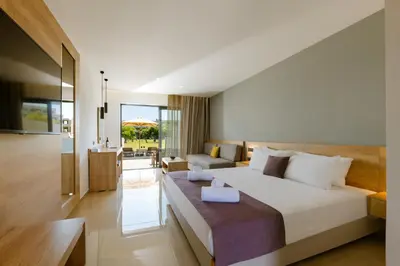 a bedroom with a bed and a living room at Galini Palace in Kolymvari
