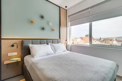 a bedroom with a bed and a window with dandelions on the wall at Koukou Central Apt -Fast WIFI- 5' to Old Town in Chania Town