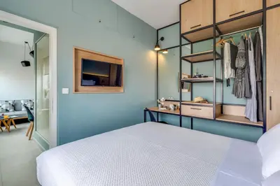 a bedroom with a white bed and a blue wall at Koukou Central Apt -Fast WIFI- 5' to Old Town in Chania Town