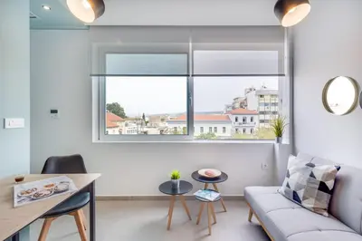 a living room with a couch and a window at Koukou Central Apt -Fast WIFI- 5' to Old Town in Chania Town