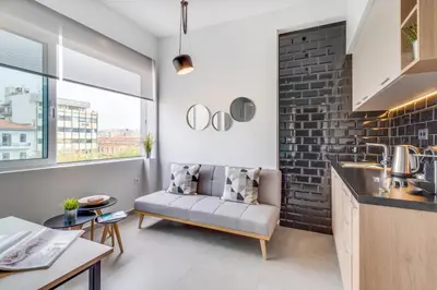 a kitchen and living room with a couch in a room at Koukou Central Apt -Fast WIFI- 5' to Old Town in Chania Town