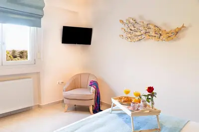 a living room with a chair and a table at LOTOS - Luxury Apartments in Kounoupidhianá
