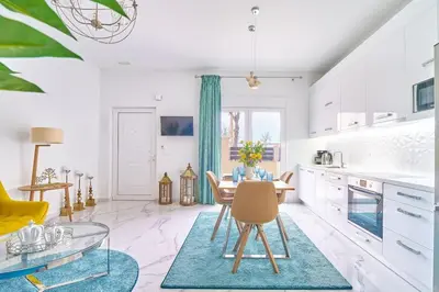 a white kitchen with a table and a dining room at Modern Luxury Studio Near Beach & Old Harbor Fast WiFi Private Veranda in Chania Town