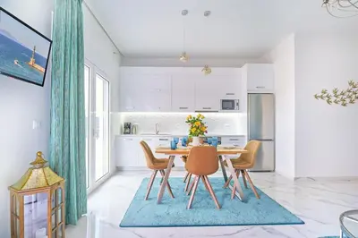 a kitchen with a table and chairs in a room at Modern Luxury Studio Near Beach & Old Harbor Fast WiFi Private Veranda in Chania Town