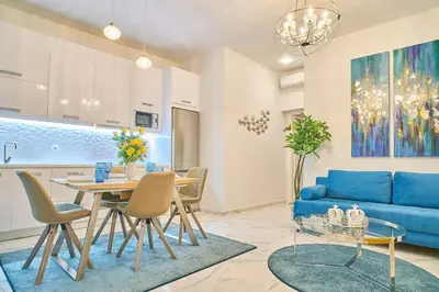 a living room with a table and a blue couch at Modern Luxury Studio Near Beach & Old Harbor Fast WiFi Private Veranda in Chania Town