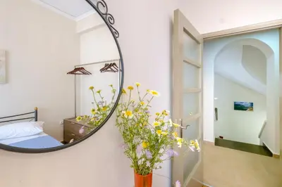 a mirror in a room with a bed and flowers at Home with Courtyard in Beating Heart of old Town! in Chania Town