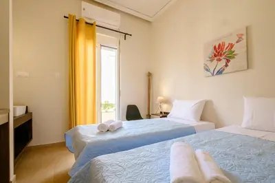 a bedroom with two beds and a window at Home with Courtyard in Beating Heart of old Town! in Chania Town