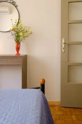 a bedroom with a bed and a vase with flowers at Home with Courtyard in Beating Heart of old Town! in Chania Town