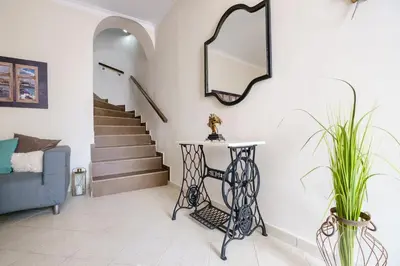 a living room with a staircase and a mirror at Home with Courtyard in Beating Heart of old Town! in Chania Town