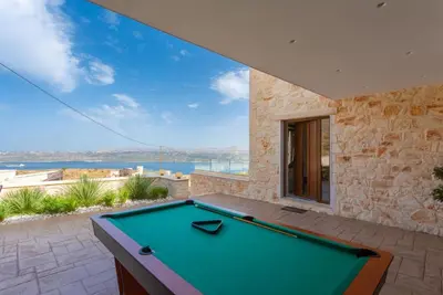 a pool table on a patio with a view of the water at Villa Lulla in Beritianá