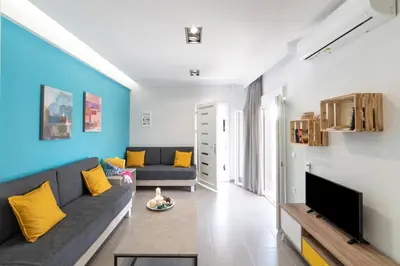 a living room with a couch and a tv at Chania Design Suites in Chania Town