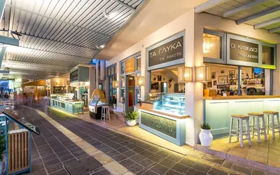 a shopping mall with tables and stools in it at Samaria by the Sea in Khóra Sfakíon