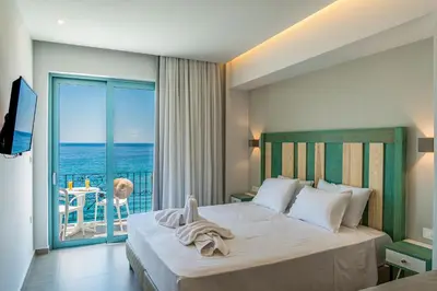 a bedroom with a bed with a view of the ocean at Samaria by the Sea in Khóra Sfakíon