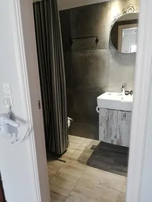 a bathroom with a sink and a mirror and a shower at Maria's Hotel in Palaiochóra