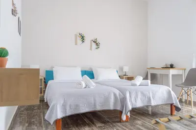 a bedroom with two beds with towels on them at Ostria Rooms in Palaiochóra