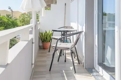 two chairs and a table on a balcony at Ostria Rooms in Palaiochóra
