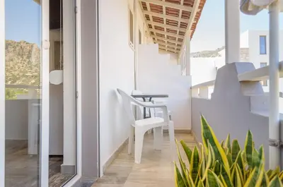 a room with a table and a chair on a balcony at Ostria Rooms in Palaiochóra