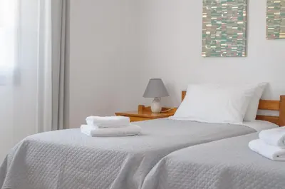 two beds with towels on top of them in a bedroom at Ostria Rooms in Palaiochóra