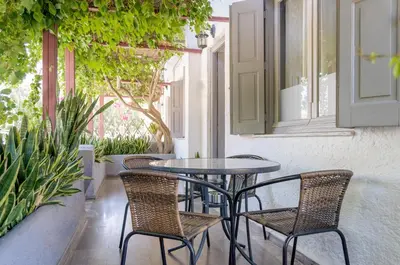 a table and chairs on a patio with plants at Ostria Rooms in Palaiochóra