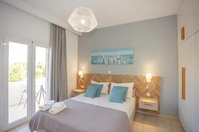 a bedroom with two beds and a balcony at Notos Villas in Frangokastello