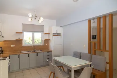 a kitchen with a table and chairs in a kitchen at Notos Villas in Frangokastello
