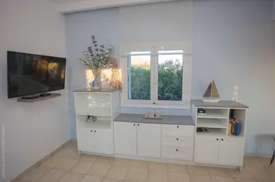 a white kitchen with a counter and a window at Notos Villas in Frangokastello