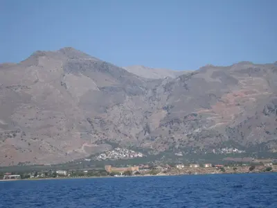 a large body of water with mountains in the background at Oasis Apartments in Frangokastello