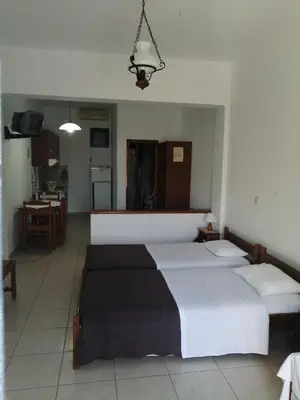 a bedroom with two beds and a kitchen at Oasis Apartments in Frangokastello