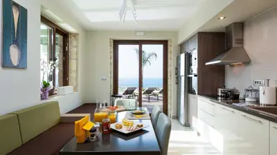 a kitchen and living room with a table with food on it at Villa Emilia I Luxury, amazing seaview, next to the town in Kissamos