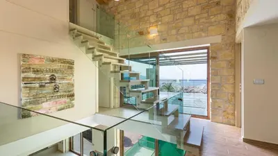 a glass staircase in a house with a brick wall at Villa Emilia I Luxury, amazing seaview, next to the town in Kissamos