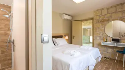 a bedroom with a bed and a mirror at Villa Emilia I Luxury, amazing seaview, next to the town in Kissamos