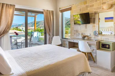 a hotel room with a bed and a balcony at Villa Alexandros in Nopíyia