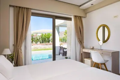 a bedroom with a bed and a desk and a mirror at Villa Alexandros in Nopíyia