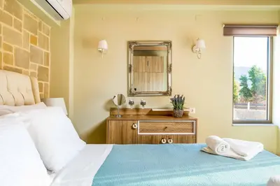 a bedroom with a bed with a mirror and a sink at Villa Elenitsa in Nopíyia