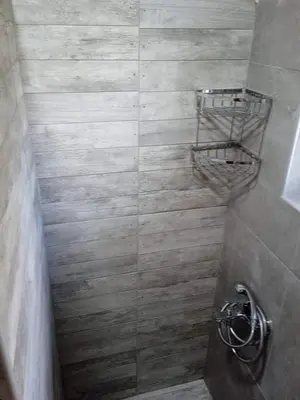 a bathroom with a shower with a basket on the wall at Ledakis Studios in Frangokastello