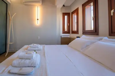 a bedroom with a large white bed with towels on it at Hanim Boutique Hotel in Chania Town