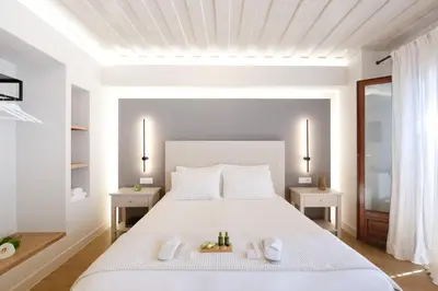 a white bedroom with a white bed and two tables at Hanim Boutique Hotel in Chania Town