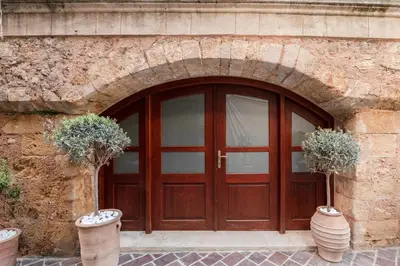 a wooden door in a stone building with two potted plants at Hanim Boutique Hotel in Chania Town