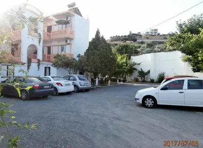 a parking lot with cars parked in front of a building at Pentari in Stalos