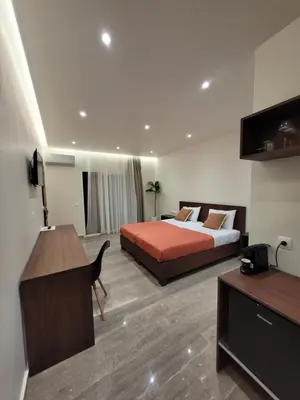 a hotel room with a bed and a desk and a computer at Vasiliki Apartments in Plataniás