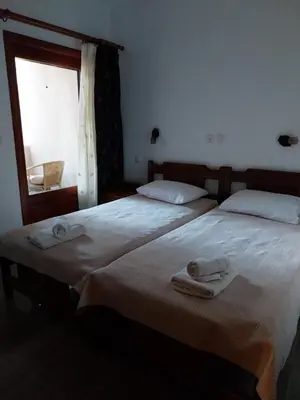two beds in a bedroom with towels on them at Vasiliki Apartments in Plataniás