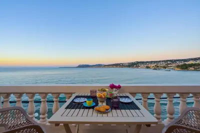 a table with food on a balcony with the ocean at Thalassa mou Seafront suite in Chania Town