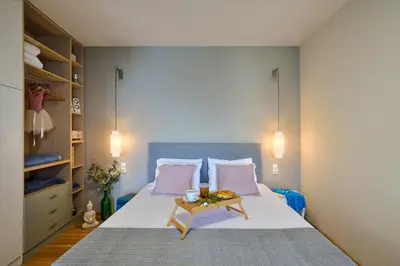 a bedroom with a bed with pink pillows and a table at Thalassa mou Seafront suite in Chania Town