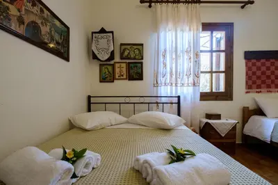 a bedroom with a bed with towels on it at Traditional Family Cretan Home! in Yerakianá