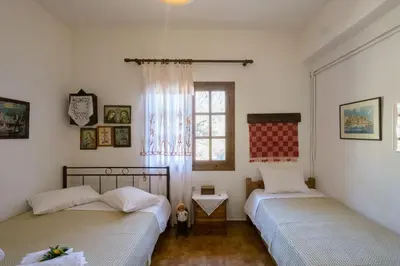 two beds in a room with a window at Traditional Family Cretan Home! in Yerakianá